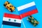 War, confrontation concept. Russia, Syria. Tanks toy near russian and Syrian flag on blue background top view