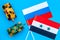War, confrontation concept. Russia, Syria. Tanks toy near russian and Syrian flag on blue background top view