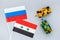 War, confrontation concept. Russia, Syria. Tanks toy near russian and Syrian flag on grey background top view