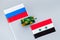 War, confrontation concept. Russia, Syria. Tanks toy near russian and Syrian flag on grey background top view