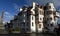 War memorial and large white house by Edinburgh Castle. People in front of a war memorial and large white house at the head of the