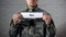 War word written on sign in hands of male soldier, armed conflict, victims