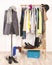 Wardrobe with clothes arranged on hangers and a winter outfit on