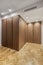 Wardrobe with root wood doors with full-length handles in the room with herringbone oak flooring, false ceiling spotlights and