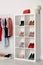 Wardrobe shelves with different stylish shoes and clothes indoors.