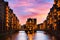 The Warehouse district Speicherstadt during beautiful twilight pink sunset in Hamburg, Germany. Illuminated warehouses in