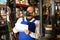 Warehouse male worker in protective mask and overalls counts the quantity of goods and writes in notebook