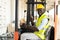 Warehouse man worker driver forklift. warehouse worker driver stacking card boxes by forklift in warehouse store. African American