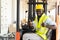 Warehouse man worker driver forklift. warehouse worker driver stacking card boxes by forklift in warehouse store. African American