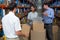 Warehouse manager carrying a box and his colleagues discussing