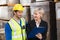 Warehouse manager showing clipboard to her colleague