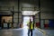 Warehouse receiver overseeing the storing of delivered items, holding tablet, looking at cargo details.