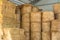 Warehouse with straw bales. Stacked Straw Hay Bales