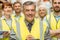 Warehouse team with arms crossed wearing yellow vest