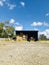 A warehouse with tractors and dry straw . Vertical.