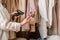 A warehouse woman employee accepts clothes using barcode scanner reading a bar code from price tag of female blouse