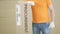 Warehouse worker with big parcel with printed PROCUREMENT text and label on it