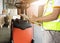 Warehouse worker holding clipboard checking on checklist load shipment goods into a truck.