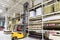 Warehouse worker loading construction materials with forklift