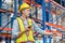 Warehouse worker man working in factory warehouse industry and using radio talking communication, Foreman in hardhat safety vest