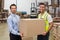Warehouse worker and manager passing a box