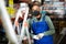 Warehouse worker in protective mask stands next to stepladder and tool shelves in hardware store