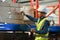 Warehouse worker in safety uniform working in warehouse full of tall shelves with goods in cardboard boxes