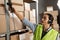 warehouse worker scans a barcode on a box in a large warehouse. brazilian woman worker scans package with barcode