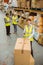 Warehouse worker sealing cardboard boxes for shipping