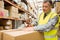 Warehouse worker sealing cardboard boxes for shipping