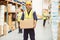 Warehouse worker smiling at camera carrying a box