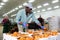 Warehouse worker sorting tomatoes and stacking them in boxes in warehouse of vegetable processing factory