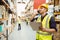 Warehouse worker talking on the phone holding clipboard