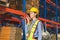 Warehouse worker working in factory warehouse industry and using radio talking communication, Foreman in hardhat safety vest with