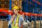 Warehouse worker working in factory warehouse industry and using radio talking communication, Foreman in hardhat safety vest with