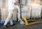 Warehouse worker working with hand pallet truck at the warehouse. cargo pallet rack. manufacturing and warehousing storage.