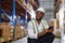 Warehouse worker working process checking the package with a tablet in a large distribution center