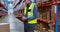 Warehouse worker writing on clipboard