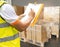 Warehouse worker writing on paper clipboard, his checking order shipment boxes on pallets. Warehouse inventory management