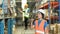 Warehouse workers in safety uniform working in warehouse full of tall shelves with goods in cardboard boxes