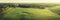 Warm aerial panorama view of picturesque autumn morning sunrise. Diagonal forest, road, crop field mist and power lines