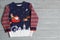 Warm Christmas sweater on grey table, top view. Space for text