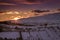 Warm and colorful sunset over Bran, a mountain village from Transylvania, covered with snow in wintertime