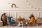 Warm and cozy kids room interior with wooden table, velvet blue, orange armchair, wooden blockers, plush animal toys, wicker