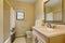 Warm creamy tones bathroom interior with wooden cabinet and mirror.