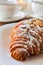 Warm crispy puff croissant in a roll on a white plate and table.