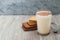 Warm Drink with Milk and cinnamon Powder on Silver Plate and Cocoa Biscuits on gray rustic Background. Horizontal image.