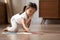 On warm floor little asian girl drawing pictures on album