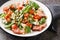 Warm french salad with bacon, spinach, roquefort cheese, walnuts, tomatoes, basil and garlic close-up in a plate. Horizontal
