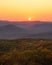 Warm golden sunlight shining across layers of rolling mountains during sunset. Overlook Mountain, NY